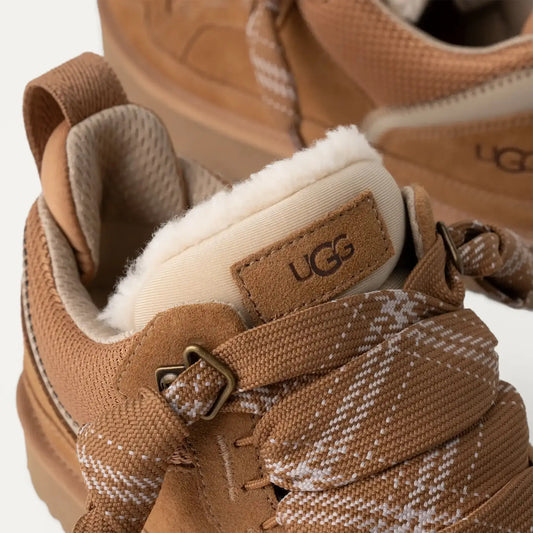 Tan UGG sneakers with thick patterned laces and plush fleece lining, close-up view.