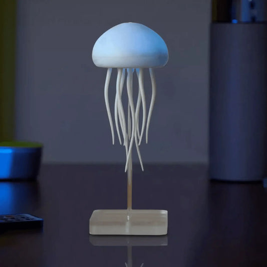 Minimalist jellyfish-shaped LED lamp with tentacle-like strands on a desk