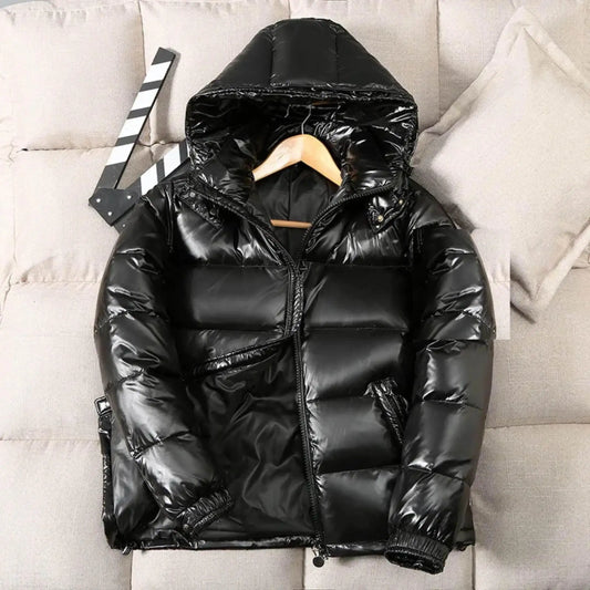 Shiny black puffer jacket with hood on hanger, displayed on beige couch with pillows.