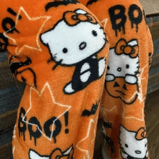Orange fuzzy pajama pants with Halloween cartoon cat, pumpkins, bats, and 'BOO!' prints.