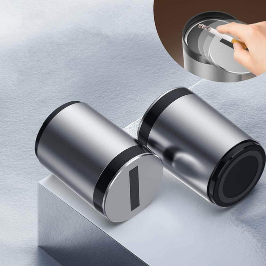 Modern stainless steel portable ashtray with lid, shown open and closed on minimal surface.