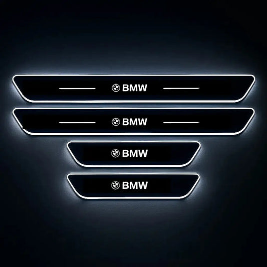 Set of four illuminated BMW car door sill protectors with white LED lighting on black background