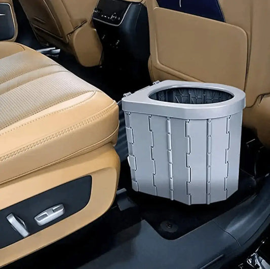 Collapsible car trash can with lid placed on rear floor between tan seats