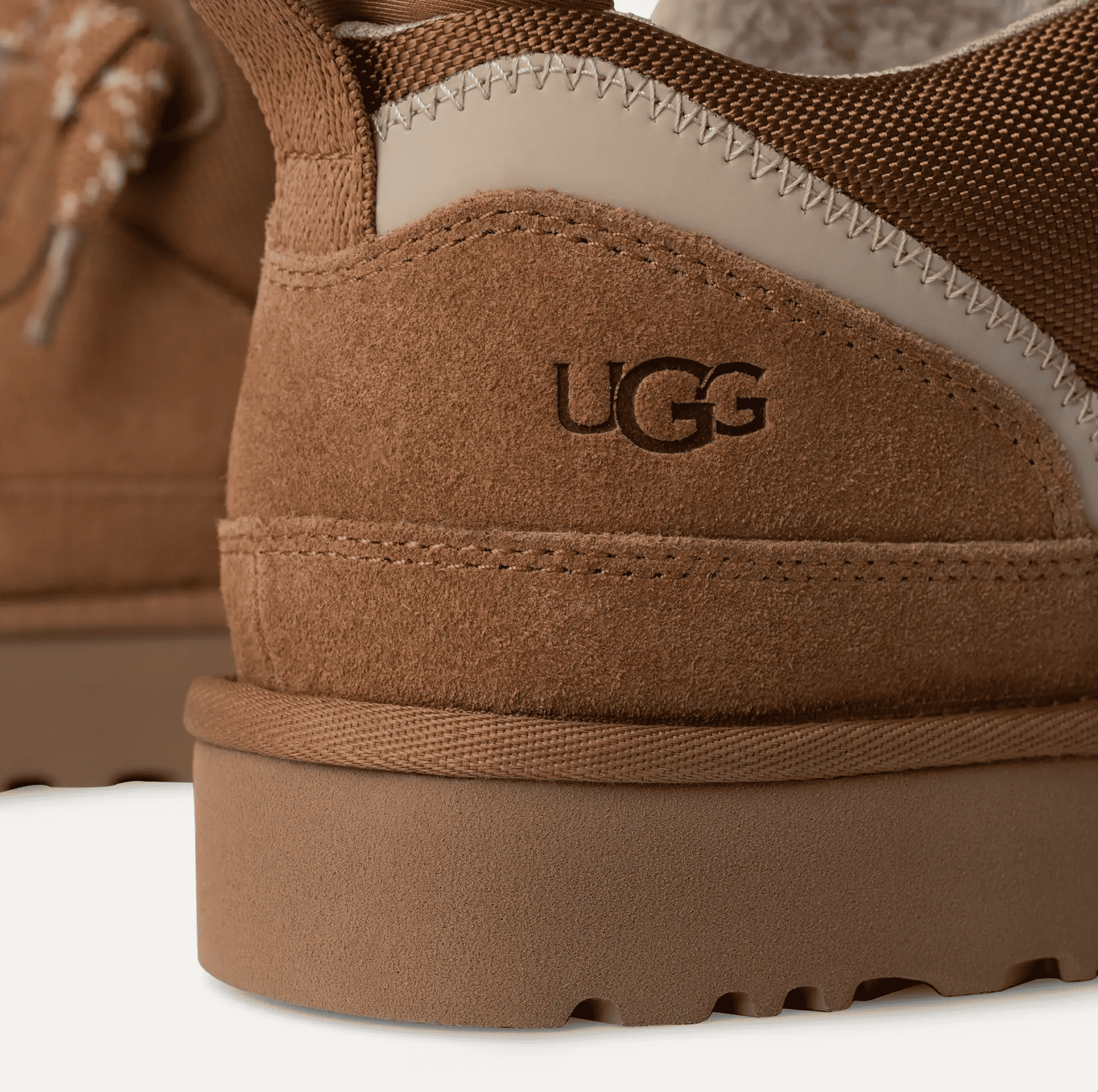 Close-up of brown suede UGG sneaker heel with textured rubber sole and visible stitching