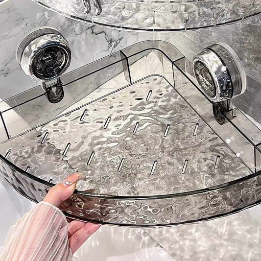 Clear textured plastic shower shelf with suction cups mounted on marble-patterned wall.