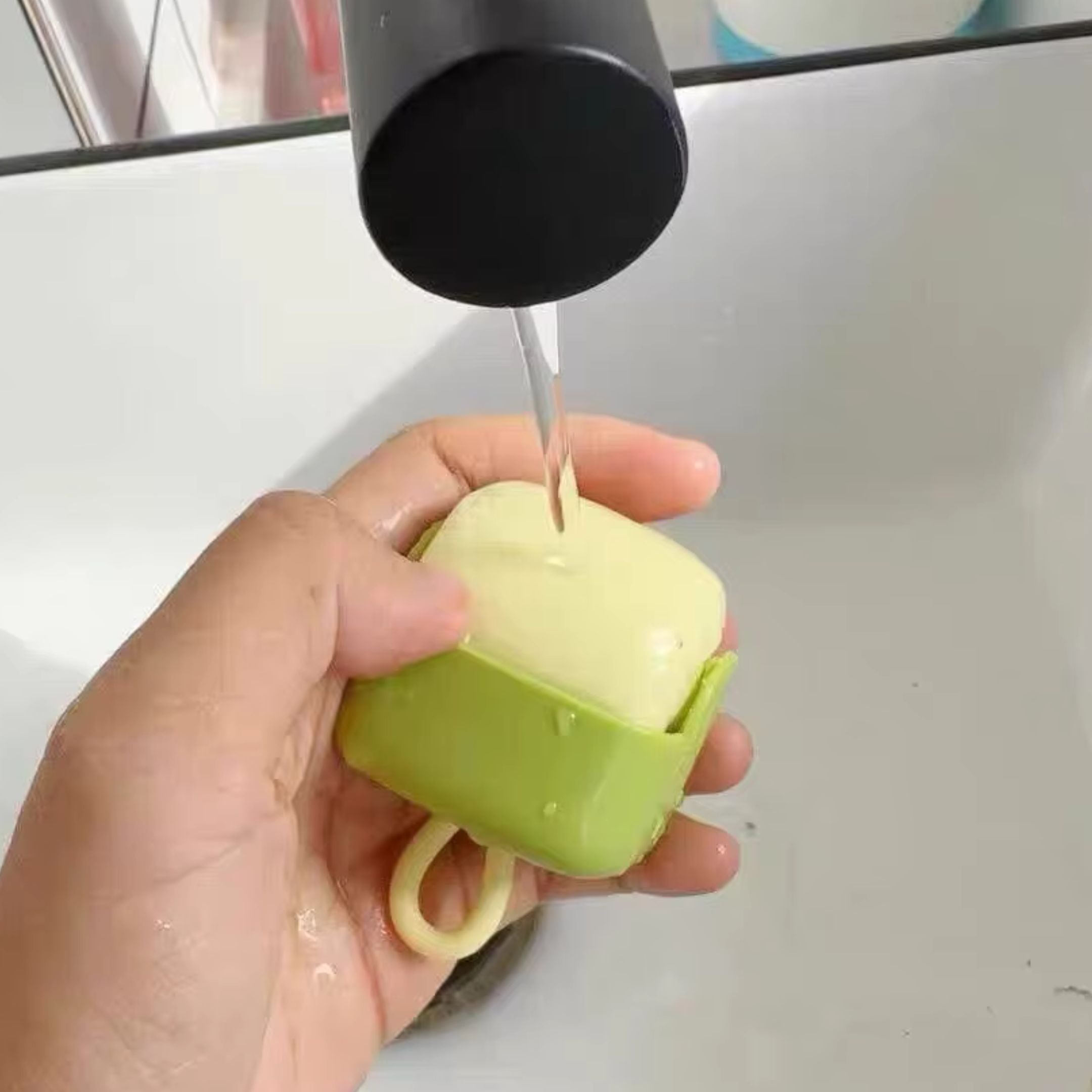 A pink handheld gaming console displays the Super Mario Bros. title screen. The console features a directional pad and several buttons. It rests on top of translucent packaging on a reflective surface.