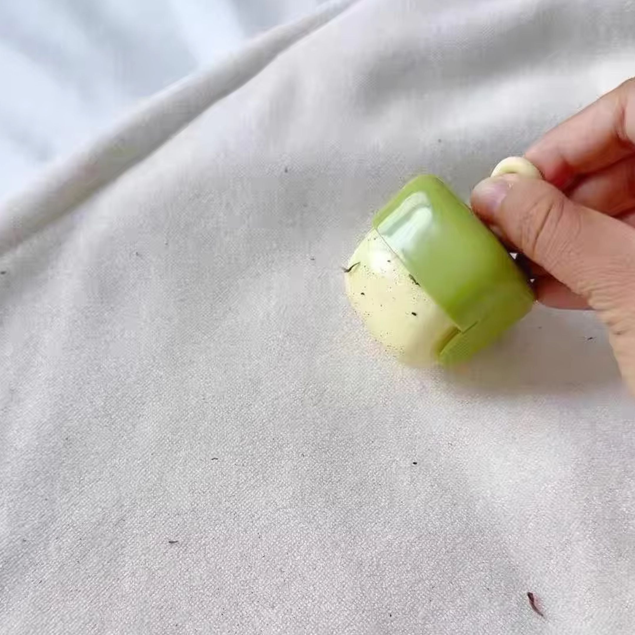 A handheld gaming device with a light blue casing displays a classic pinball game on its screen. The device has a black directional pad and four buttons. A persons hand holds it on the left side.